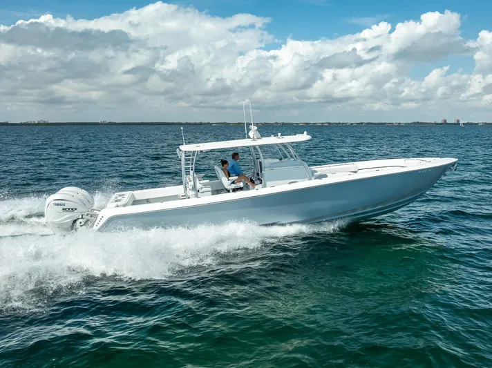  Yacht Photos Pics 2025 Contender 44 ST boat cruising on open water under a partly cloudy sky.