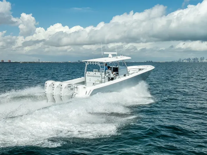  Yacht Photos Pics 2025 Contender 44 ST boat cruising on open water under a cloudy sky.