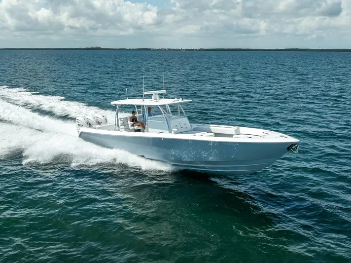  Yacht Photos Pics 2025 Contender 44 ST boat cruising on open water under a cloudy sky.