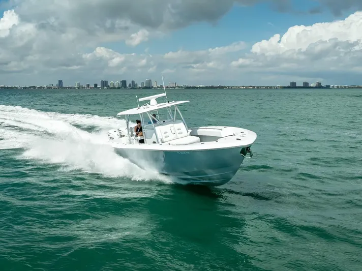  Yacht Photos Pics 2025 Contender 44 ST boat cruising on open water under a cloudy sky.