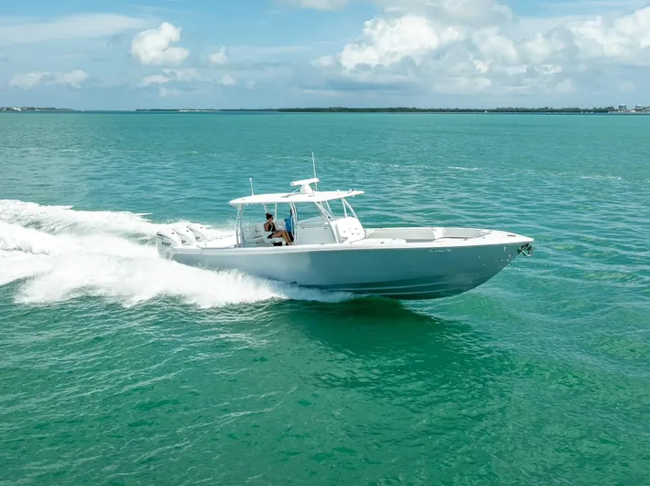  Yacht Photos Pics 2025 Contender 44 ST boat cruising on turquoise ocean waters under a clear sky.