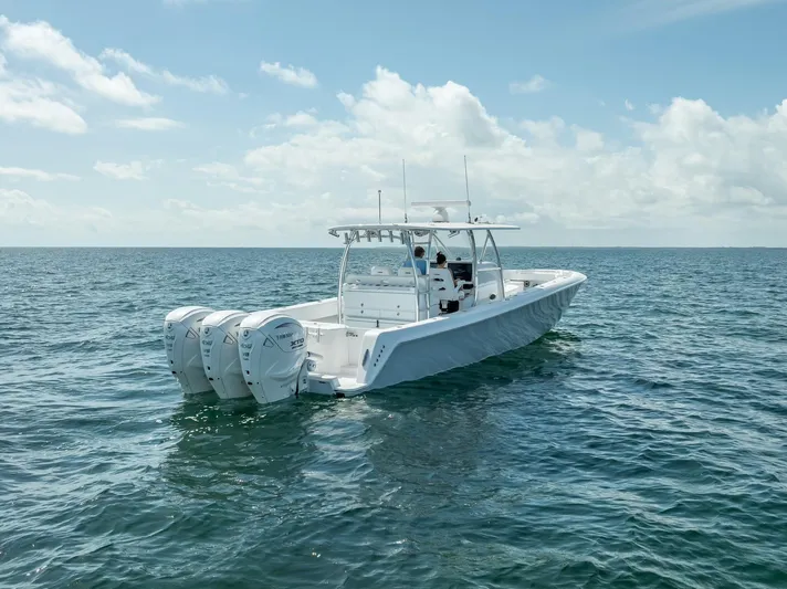  Yacht Photos Pics 2025 Contender 44 ST boat with triple engines on open water under a clear sky.