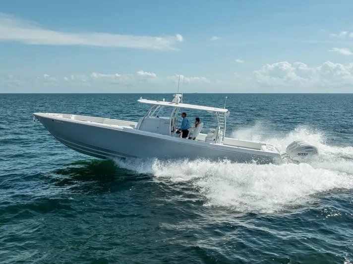  Yacht Photos Pics 2025 Contender 44 ST boat cruising on open sea under clear blue sky.