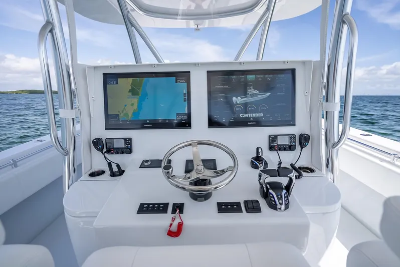  Yacht Photos Pics 2025 Contender 44 ST boat dashboard with dual navigation screens and steering wheel.