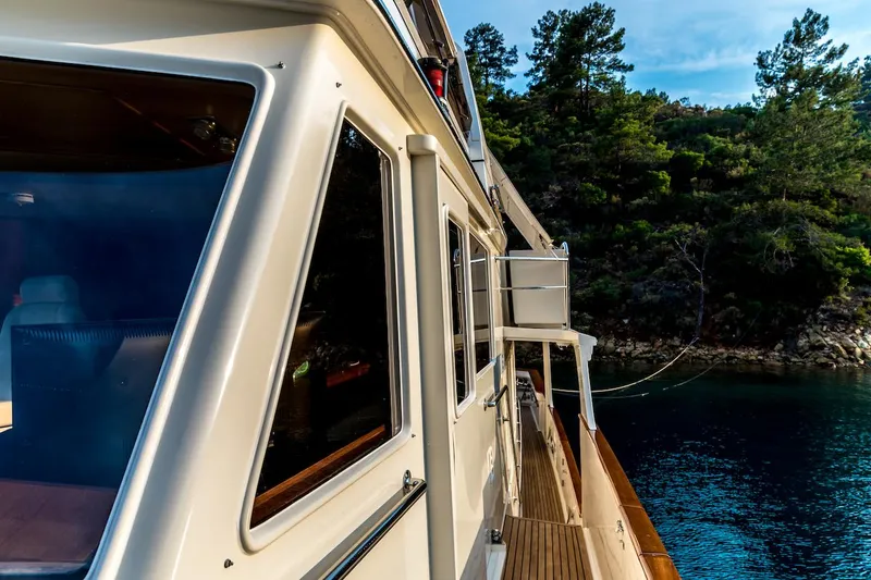 Perseus Yacht Photos Pics Side view of a 2004 Fleming 75 yacht near a forested shoreline.