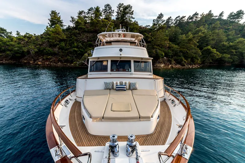 Perseus Yacht Photos Pics Luxurious 2004 Fleming 75 yacht on serene water, surrounded by lush greenery.