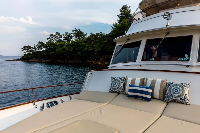 Perseus Yacht Photos Pics Luxurious 2004 Fleming 75 yacht with cushioned deck, scenic ocean view, and lush greenery.