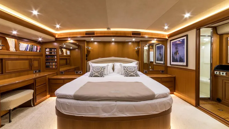 Perseus Yacht Photos Pics Luxurious bedroom interior on a 2004 Fleming 75 yacht, featuring elegant wood paneling and ambient lighting.