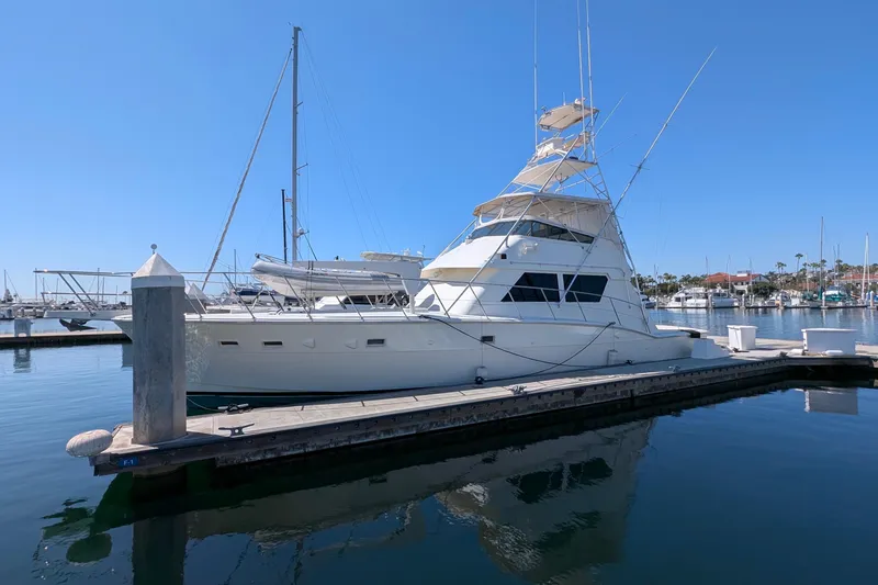 Mas Fina Yacht Photos Pics 1987 Hatteras Convertible yacht docked in a marina under clear blue skies.
