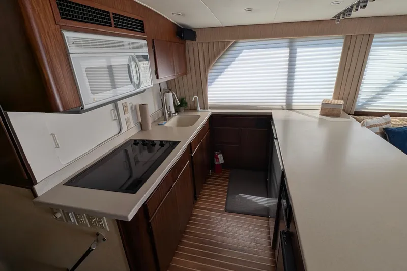 Mas Fina Yacht Photos Pics 1987 Hatteras Convertible yacht kitchen with modern appliances and wood cabinetry.