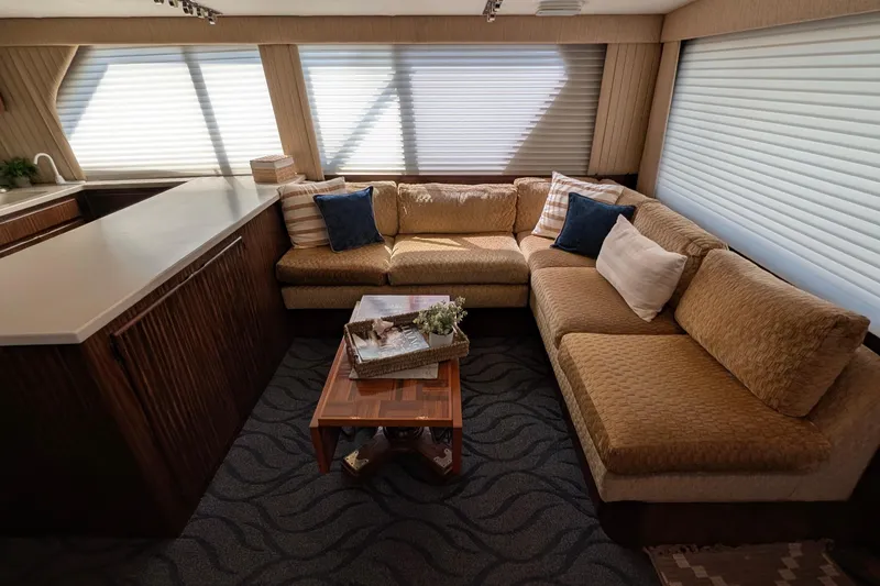 Mas Fina Yacht Photos Pics Luxurious 1987 Hatteras Convertible yacht interior with cozy beige sectional sofa and elegant decor.