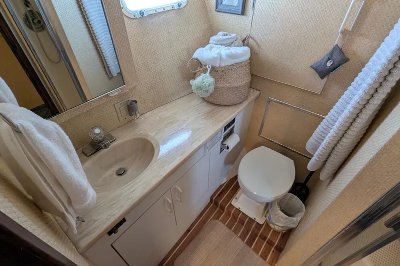 Mas Fina Yacht Photos Pics 1987 Hatteras Convertible yacht bathroom with sink, toilet, and towels.