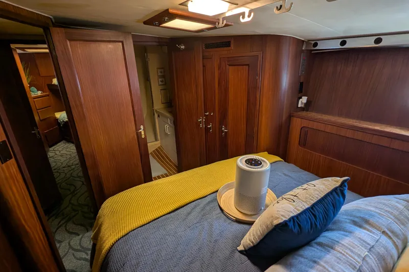 Mas Fina Yacht Photos Pics Interior of 1987 Hatteras Convertible yacht bedroom with wood paneling and cozy bedding.