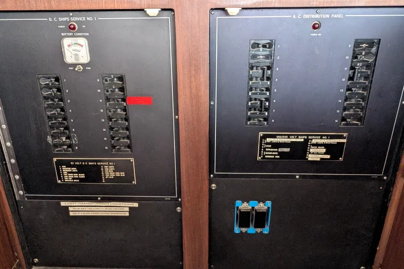 Mas Fina Yacht Photos Pics Electrical panel of a 1987 Hatteras Convertible boat, featuring DC and AC distribution.
