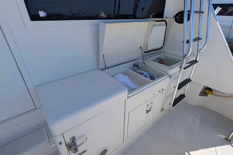 Mas Fina Yacht Photos Pics 1987 Hatteras Convertible yacht deck with storage compartments and ladder.