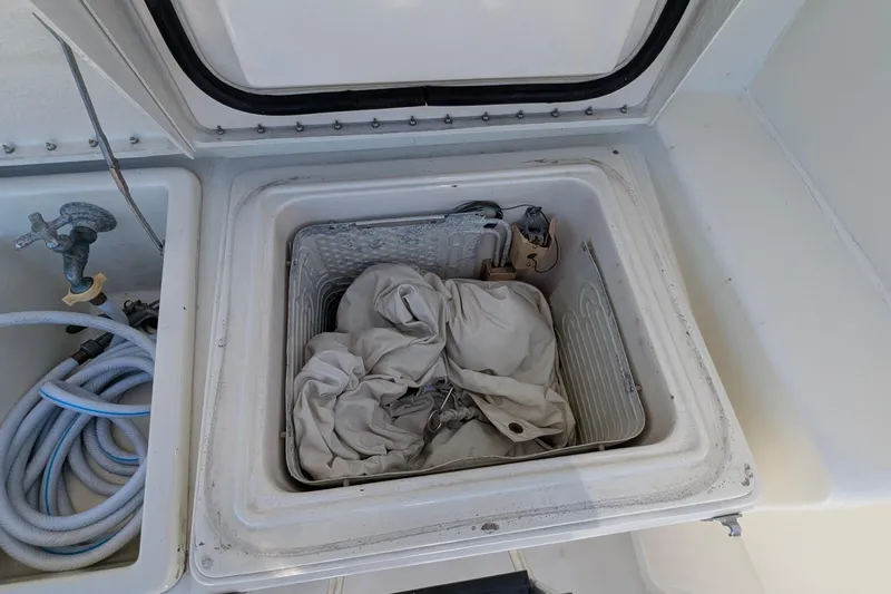 Mas Fina Yacht Photos Pics Storage compartment on a 1987 Hatteras Convertible boat with hoses and fabric.