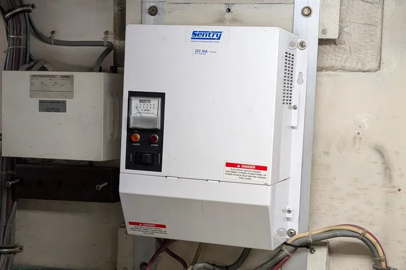Mas Fina Yacht Photos Pics Electrical panel on a 1987 Hatteras Convertible boat, featuring a Sentry charger.