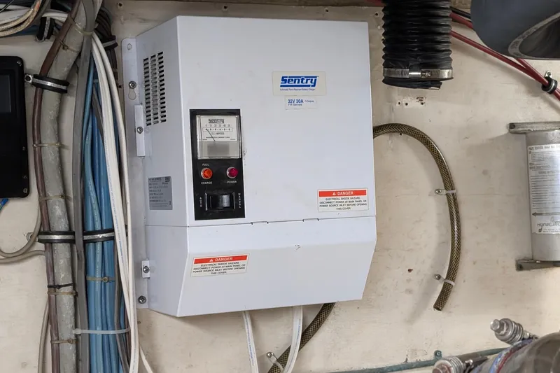 Mas Fina Yacht Photos Pics Electrical panel on a 1987 Hatteras Convertible boat, featuring Sentry battery charger.