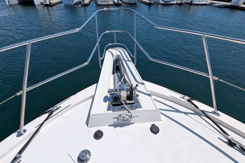 Mas Fina Yacht Photos Pics Bow view of 1987 Hatteras Convertible yacht in marina, showcasing anchor and railing.