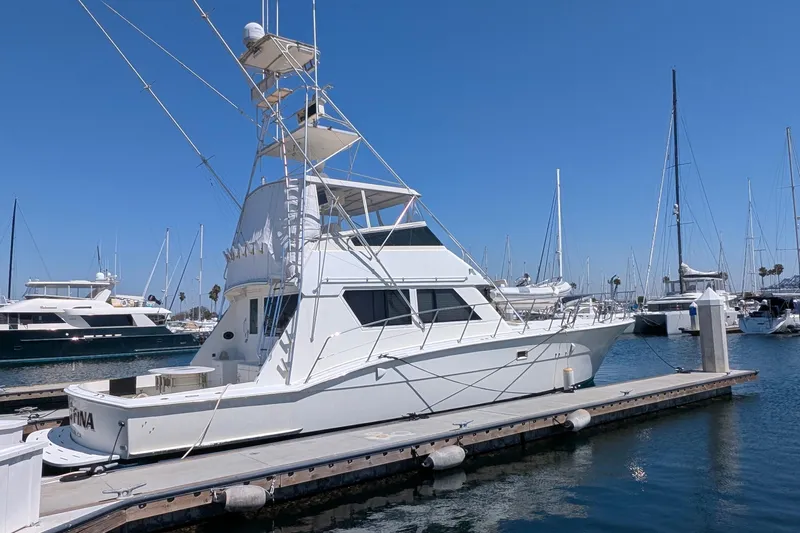 Mas Fina Yacht Photos Pics 1987 Hatteras Convertible yacht docked at a marina under clear blue skies.