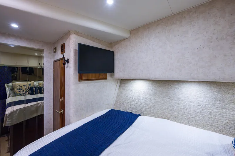 Miss Elena*eous Yacht Photos Pics Luxurious cabin interior of 2004 Egg Harbor 43 Sport Fisherman with TV and elegant bedding.