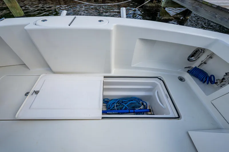 Miss Elena*eous Yacht Photos Pics 2004 Egg Harbor 43 Sport Fisherman deck with storage compartment and coiled hose.