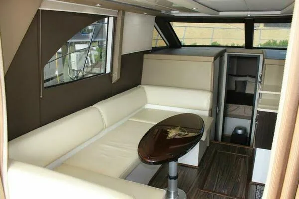 Boundless Yacht Photos Pics Interior of 2013 Carver C34 Command Bridge yacht with beige seating and wooden table.