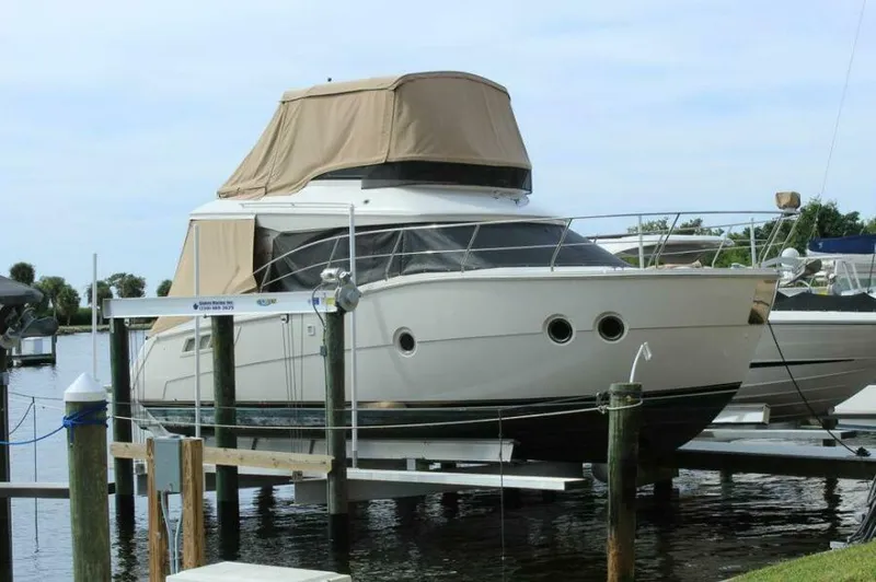 Boundless Yacht Photos Pics 2013 Carver C34 Command Bridge yacht docked at marina with beige canopy.