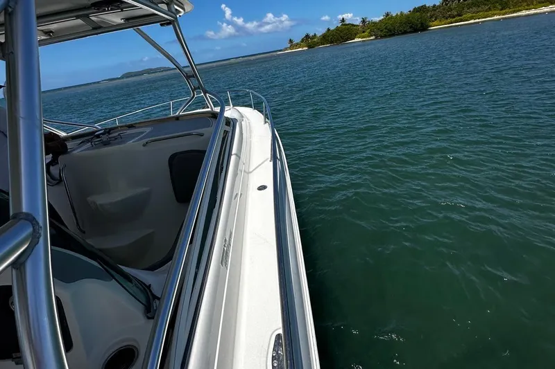  Yacht Photos Pics 2006 Hydra-Sports Vector 3300 VX cruising on clear blue waters near a lush island.