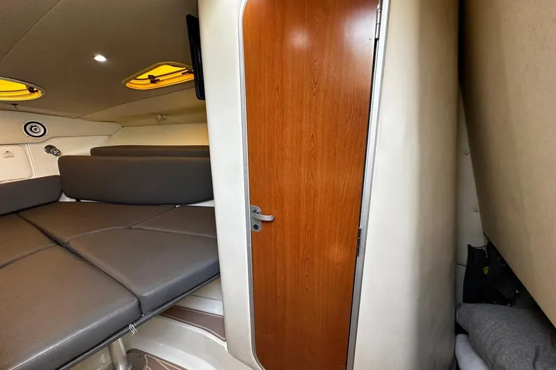  Yacht Photos Pics 2006 Hydra-Sports Vector 3300 VX cabin interior with wooden door and cushioned seating.
