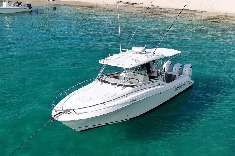  Yacht Photos Pics 2006 Hydra-Sports Vector 3300 VX boat anchored in clear turquoise water near a sandy beach.