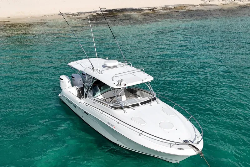  Yacht Photos Pics 2006 Hydra-Sports Vector 3300 VX boat anchored in clear turquoise water near a sandy beach.