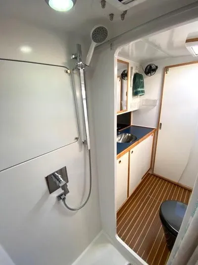 Saphira Yacht Photos Pics Bathroom interior of 2018 Chris White Atlantic 70 "SAPHIRA" yacht, featuring shower and wooden flooring.