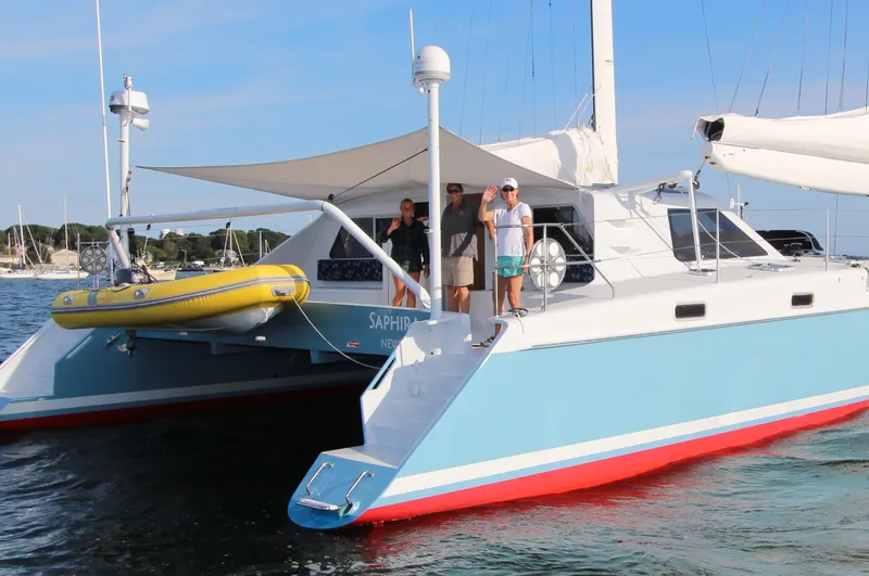 Saphira Yacht Photos Pics Atlantic 70 "SAPHIRA" catamaran with people onboard, featuring a yellow dinghy, 2018 model.