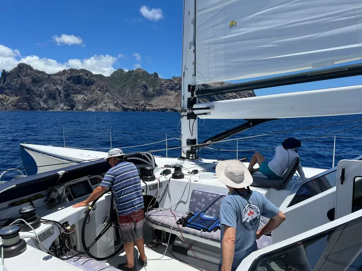 Saphira Yacht Photos Pics Sailing on Chris White Atlantic 70 "SAPHIRA" yacht, 2018, with scenic ocean and mountain backdrop.