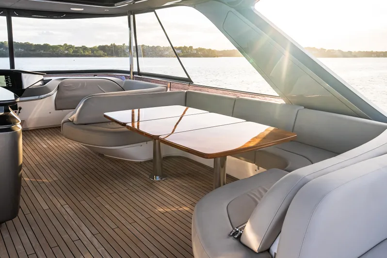 Stella Maris Yacht Photos Pics Luxurious 2022 Princess Y72 Motor Yacht interior with elegant seating and wooden table, overlooking serene waters.