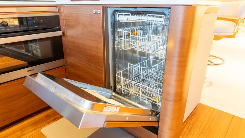 Stella Maris Yacht Photos Pics Open dishwasher in 2022 Princess Y72 Motor Yacht kitchen, showcasing modern interior design.