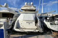 2007 Azimut 68E yacht docked at marina, rear view with covered deck.
