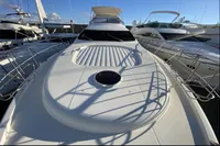 2007 Azimut 68E yacht with sleek deck design, docked in a marina under clear skies.
