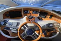 2007 Azimut 68E yacht helm with wooden steering wheel and modern navigation controls.
