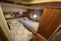 Luxurious cabin interior of 2007 Azimut 68E yacht with twin beds and elegant decor.