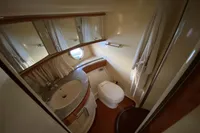 Luxurious bathroom in 2007 Azimut 68E yacht with modern fixtures and porthole window.