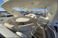 2007 Azimut 68E yacht with spacious deck and seating area in marina.