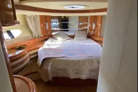 Luxurious bedroom interior of a 2007 Azimut 68E yacht with elegant wood finishes.