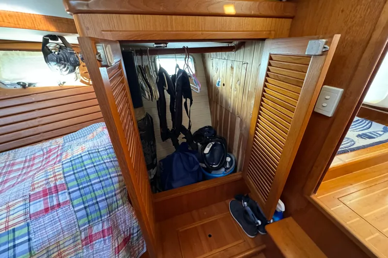  Yacht Photos Pics Cozy cabin interior of 2000 Pacific Seacraft 38T Fast Trawler with wooden closet and bed.
