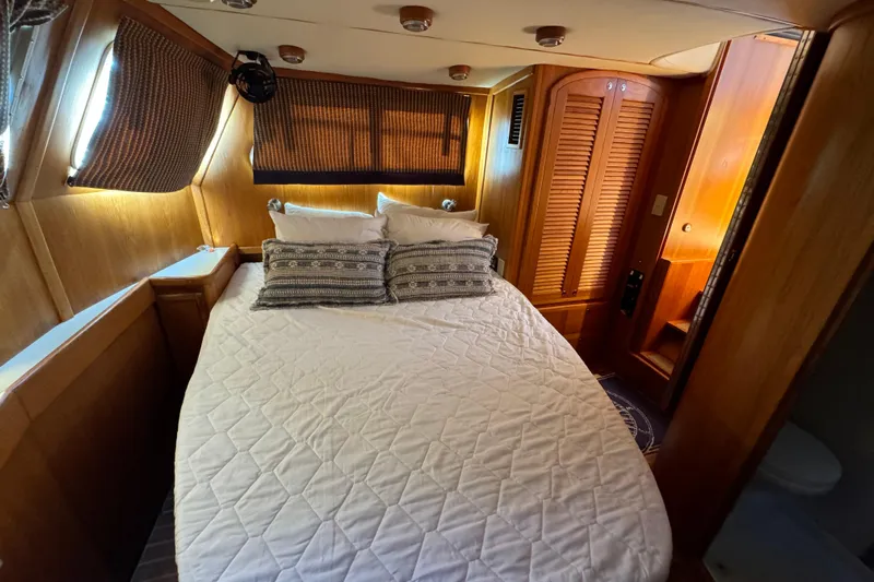  Yacht Photos Pics Cozy bedroom in 2000 Pacific Seacraft 38T Fast Trawler with wood paneling and comfortable bedding.