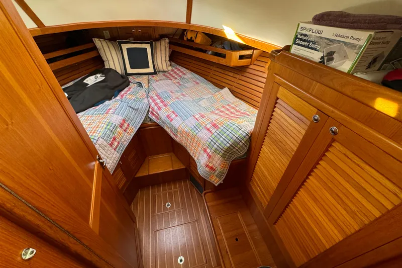  Yacht Photos Pics Cozy cabin interior of 2000 Pacific Seacraft 38T Fast Trawler with wooden finish and colorful bedding.