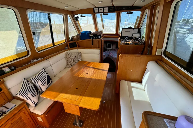  Yacht Photos Pics Interior of 2000 Pacific Seacraft 38T Fast Trawler with cozy seating and wooden table.