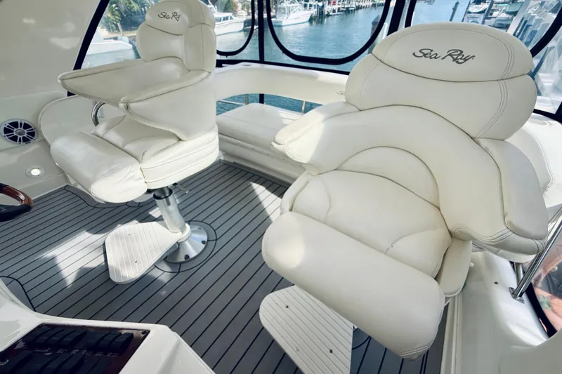 Rogue One Yacht Photos Pics Luxurious seating on 2003 Sea Ray 560 Sedan Bridge yacht, featuring plush white captain chairs.