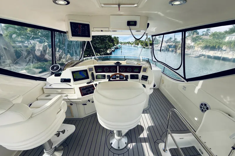 Rogue One Yacht Photos Pics 2003 Sea Ray 560 Sedan Bridge helm with modern navigation equipment and waterfront view.